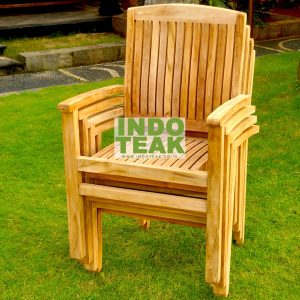 Premium solid teak stacking armchair stacked on green lawn by CV. Indoteak Sukses Makmur, Indonesian outdoor furniture exporter